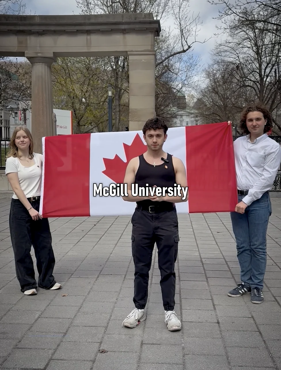 Justice speaking at campus gates in front of a Canadian flag