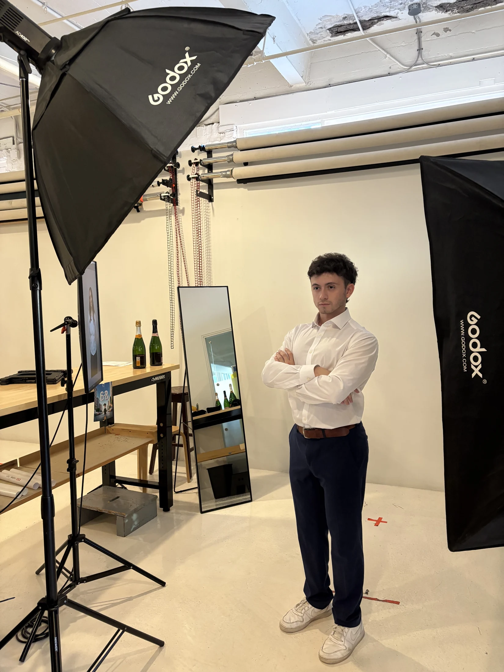Justice standing with his arms folded in a photography studio