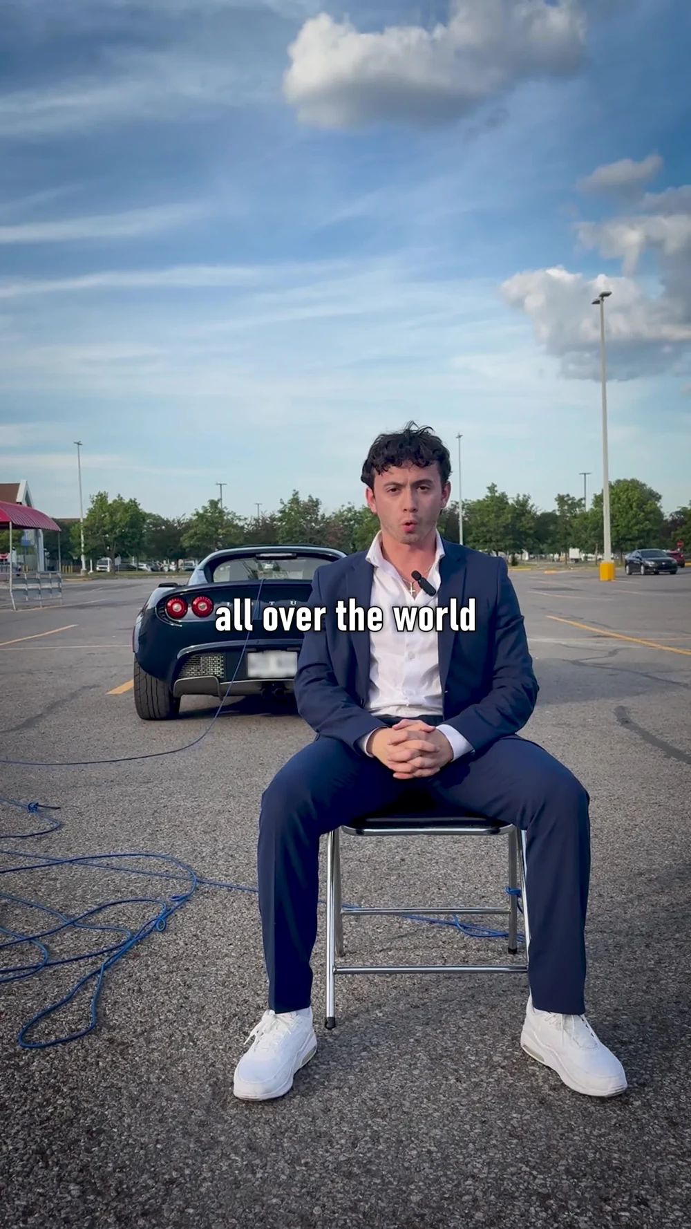 Justice in a navy suit speaking to camera from a chair outdoors